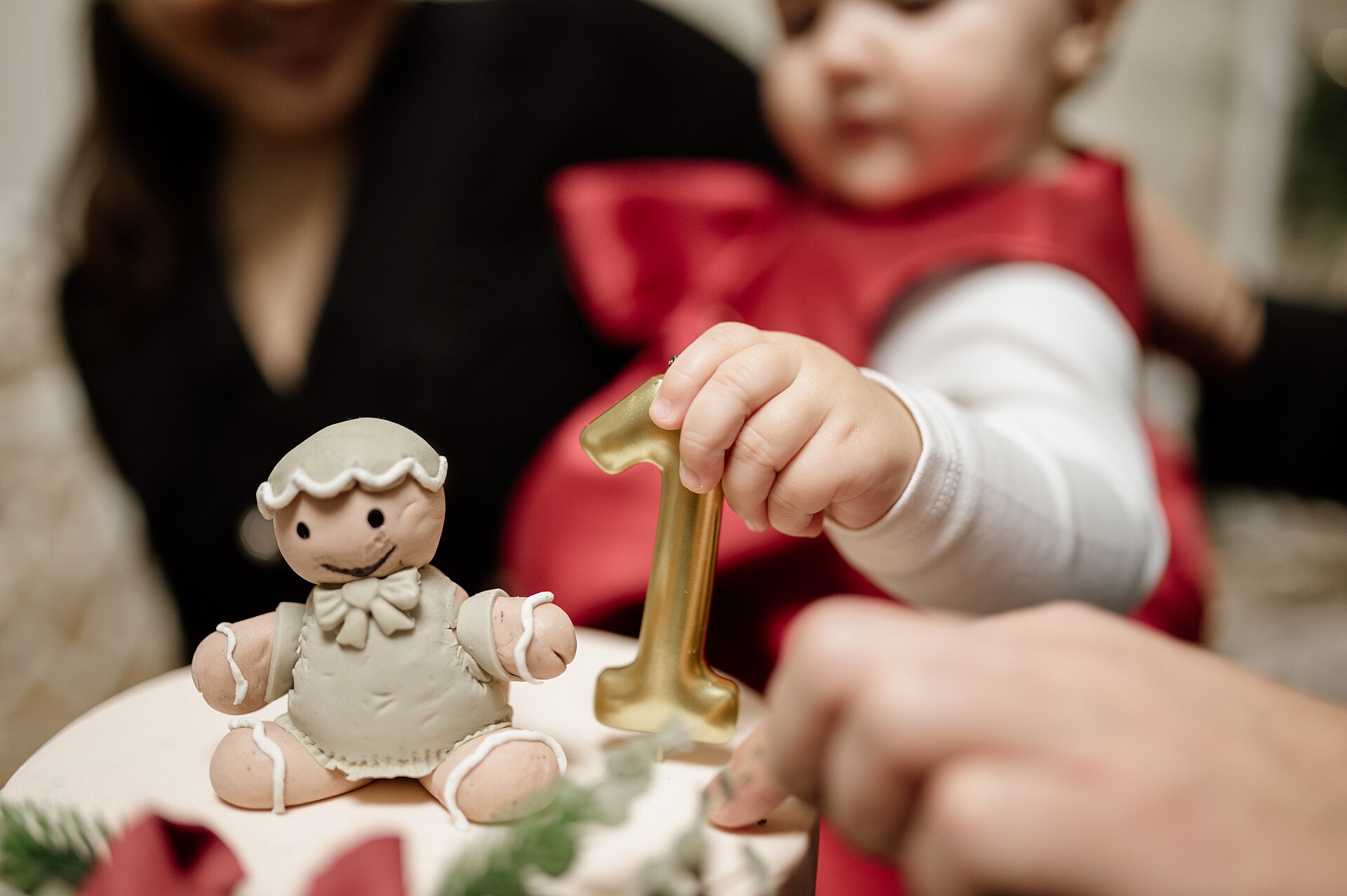 Child reaching for a number one birthday candle